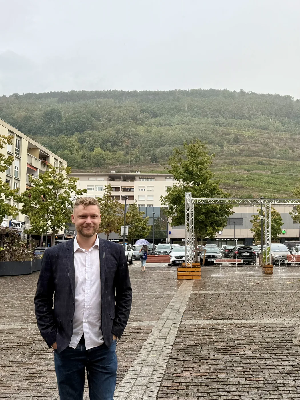 Guillaume Nobel sur une place de Guebwiller, les coteaux de vignes en arrière-plan