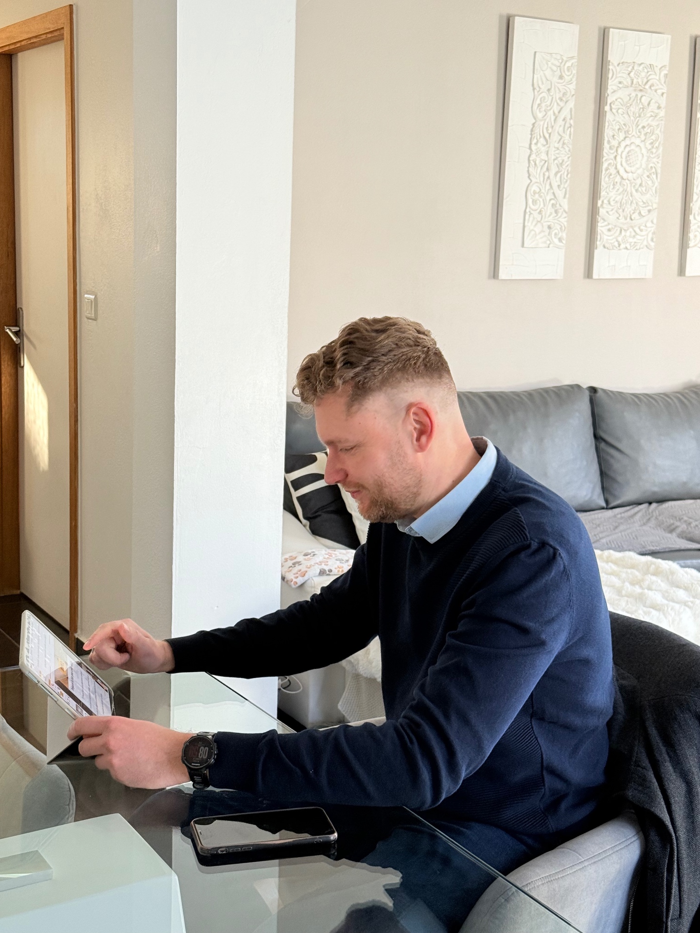 Guillaume Nobel, conseiller immobilier, devant une maison alsacienne avec une tablette à la main.